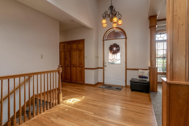 entryway featuring light wood-type flooring and a notable chandelier