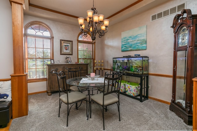 dining room with a chandelier, carpet floors, and crown molding