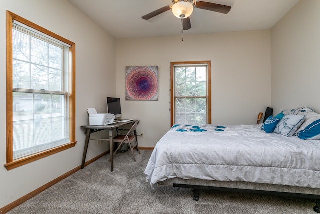 carpeted bedroom with multiple windows and ceiling fan