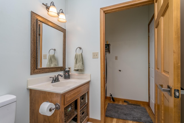 bathroom with vanity, toilet, and wood-type flooring