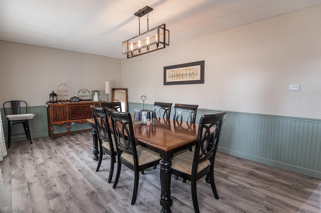 dining area with hardwood / wood-style floors and a textured ceiling