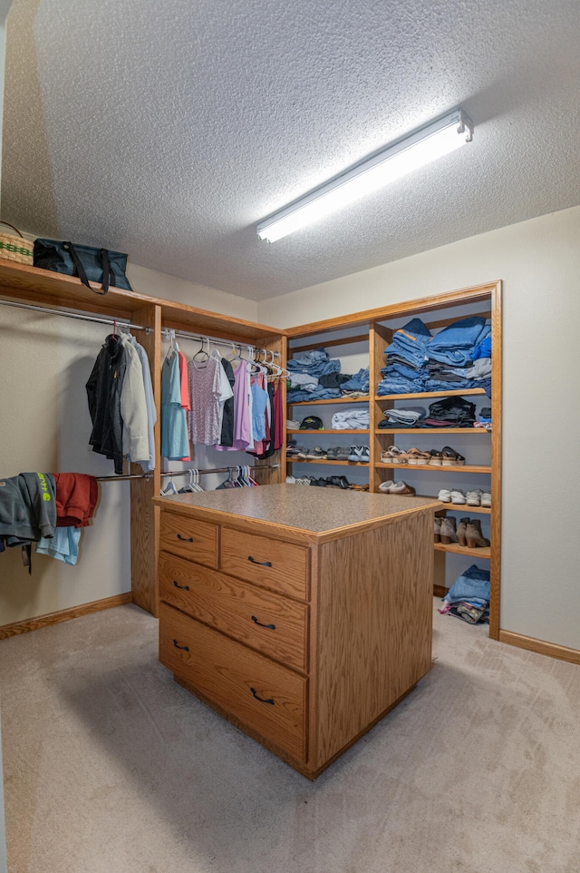 walk in closet featuring light colored carpet