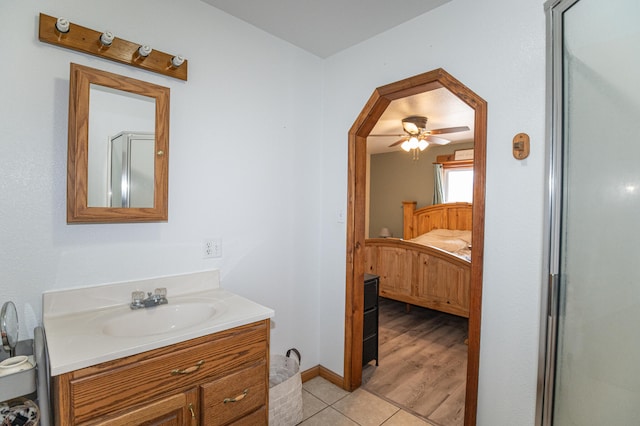 bathroom with ceiling fan, a shower with shower door, vanity, and tile patterned floors