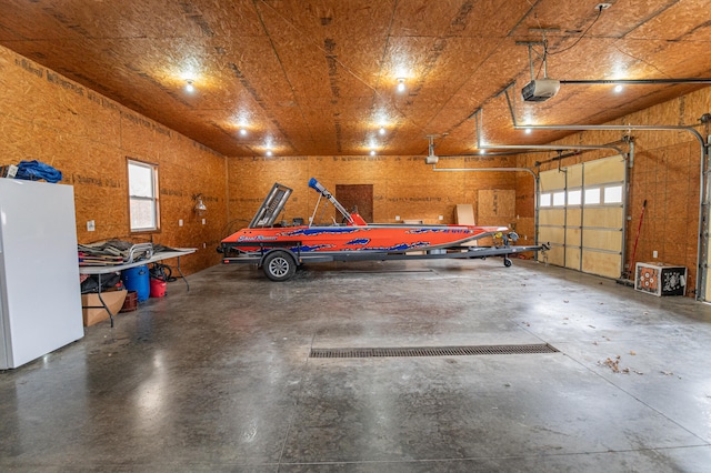 garage with a garage door opener and white fridge