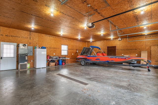 garage with a garage door opener, electric panel, and white fridge