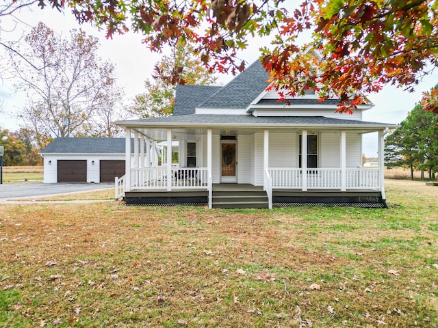 view of front of house featuring an outbuilding, a garage, covered porch, and a front lawn