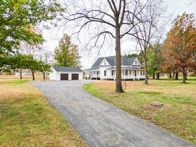 view of front of house with covered porch, a garage, and a front yard