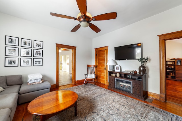 living room featuring a fireplace, hardwood / wood-style flooring, and ceiling fan