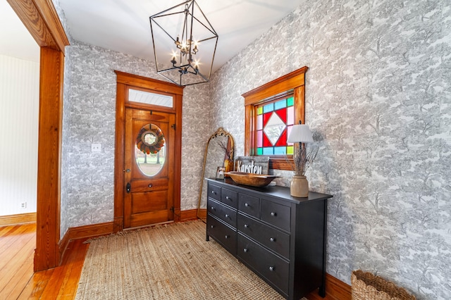 foyer featuring light wood-type flooring and a chandelier