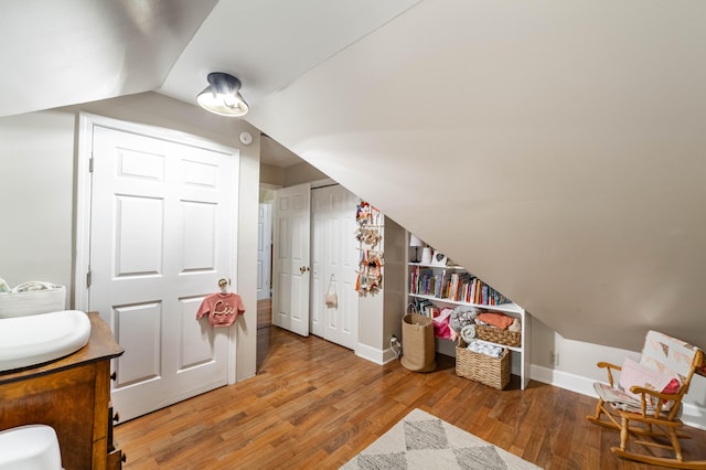 interior space with hardwood / wood-style flooring and lofted ceiling