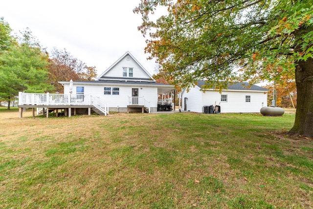 back of property with a wooden deck, cooling unit, and a yard