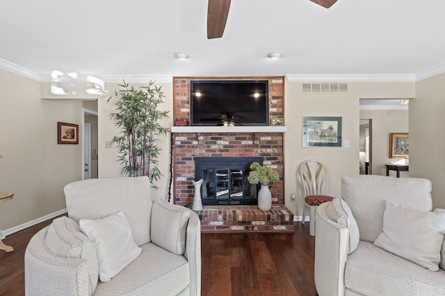 living room with ornamental molding, a brick fireplace, and dark wood-type flooring