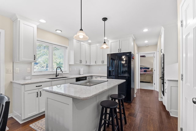 kitchen featuring white cabinets, black appliances, sink, dark hardwood / wood-style floors, and a kitchen island