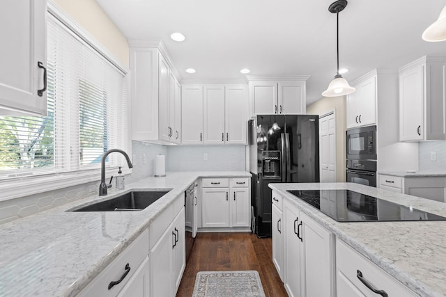 kitchen featuring dark hardwood / wood-style flooring, white cabinets, hanging light fixtures, black appliances, and sink