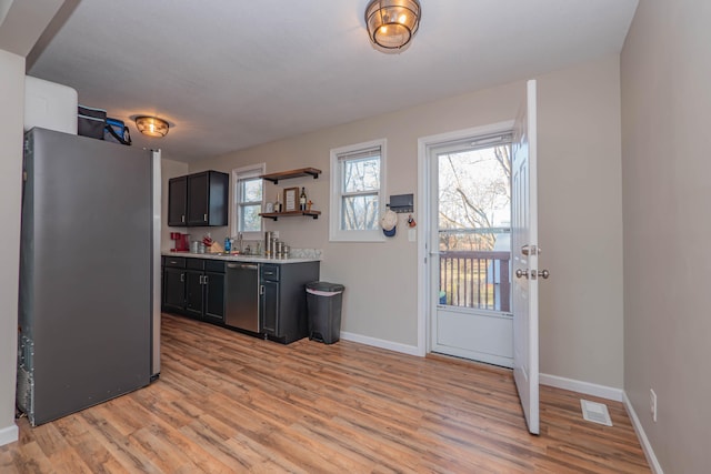 kitchen featuring appliances with stainless steel finishes, sink, and light hardwood / wood-style floors