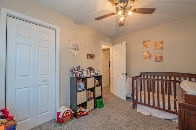 bedroom with a closet, carpet flooring, ceiling fan, and a crib