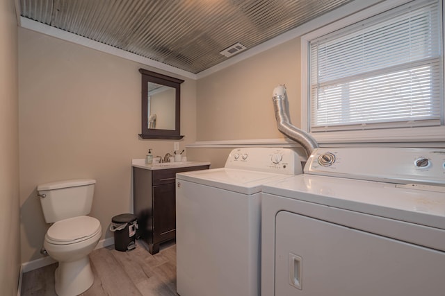 clothes washing area featuring washer and clothes dryer and light hardwood / wood-style floors