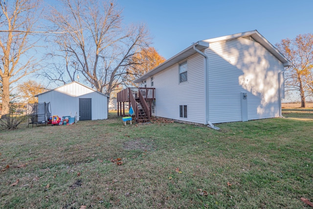 view of property exterior with a deck, a shed, and a lawn