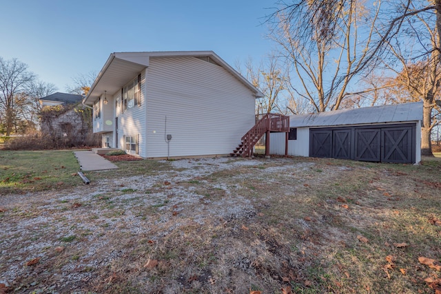 rear view of property with a lawn and an outdoor structure