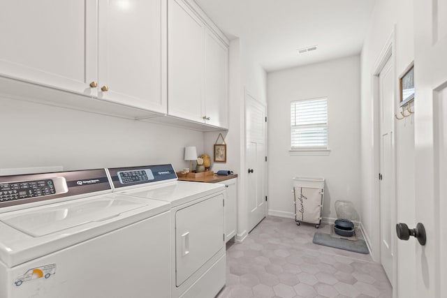 clothes washing area featuring cabinets and independent washer and dryer