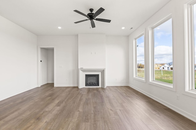 unfurnished living room featuring ceiling fan and light wood-type flooring