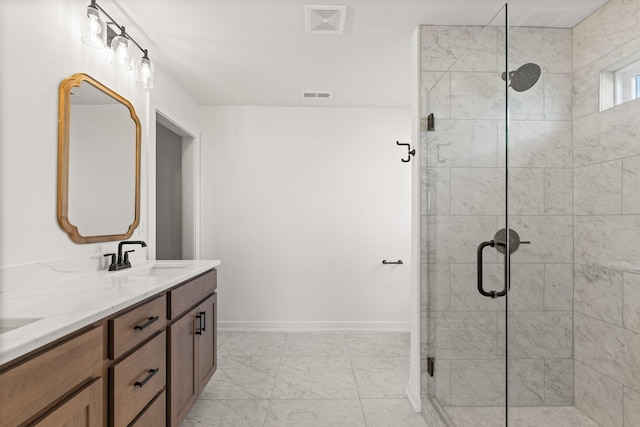bathroom featuring a shower with shower door and vanity