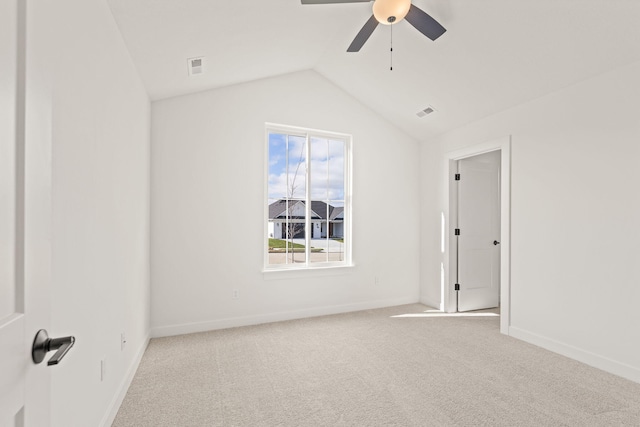 carpeted empty room with ceiling fan and vaulted ceiling