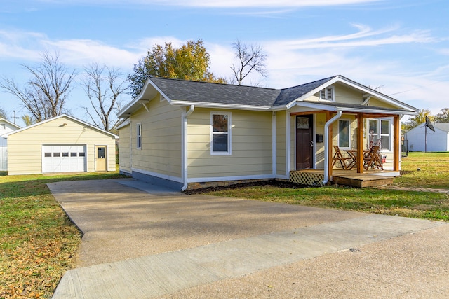 view of front of home featuring a front lawn, a garage, and an outbuilding