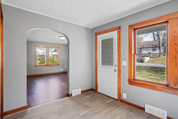 201 N Evans St, Armstrong, MO 65230 - foyer featuring arched walkways, wood finished floors, crown molding, and baseboards