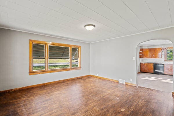 201 N Evans St, Armstrong, MO 65230 - empty room featuring arched walkways, wood finished floors, crown molding, and baseboards