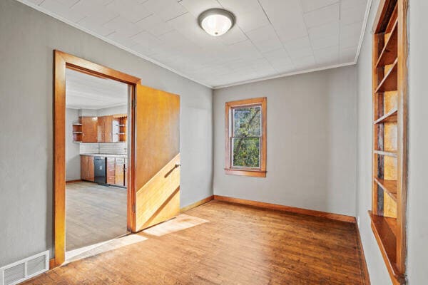 201 N Evans St, Armstrong, MO 65230 - spare room featuring ornamental molding, wood finished floors, and baseboards