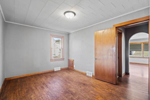 201 N Evans St, Armstrong, MO 65230 - empty room with ornamental molding, wood finished floors, baseboards, and arched walkways