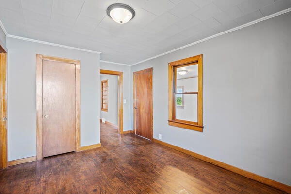 unfurnished bedroom featuring dark hardwood / wood-style floors and ornamental molding