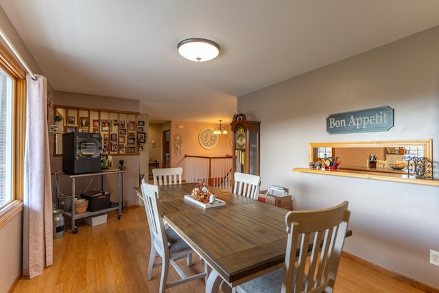 dining area with a chandelier, a healthy amount of sunlight, and light wood-type flooring