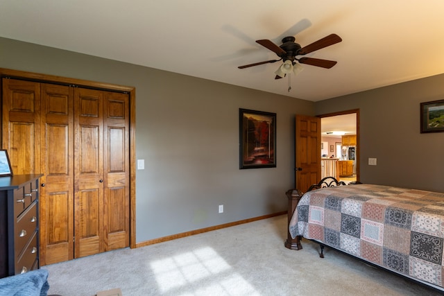 bedroom with ceiling fan, a closet, and light colored carpet