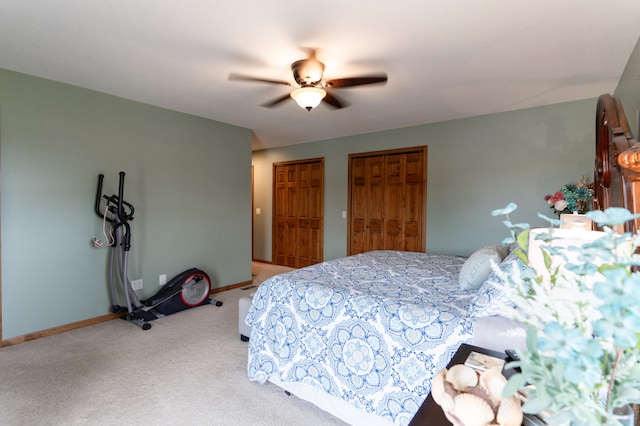 bedroom with light carpet, two closets, and ceiling fan