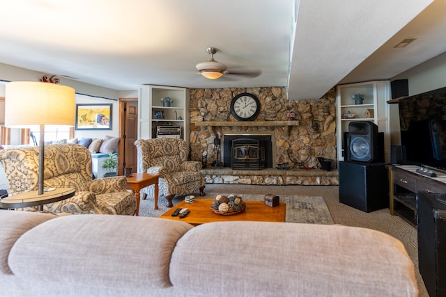 carpeted living room featuring a wood stove and ceiling fan