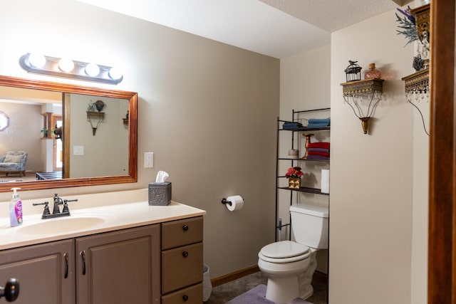 bathroom with vanity, a textured ceiling, and toilet