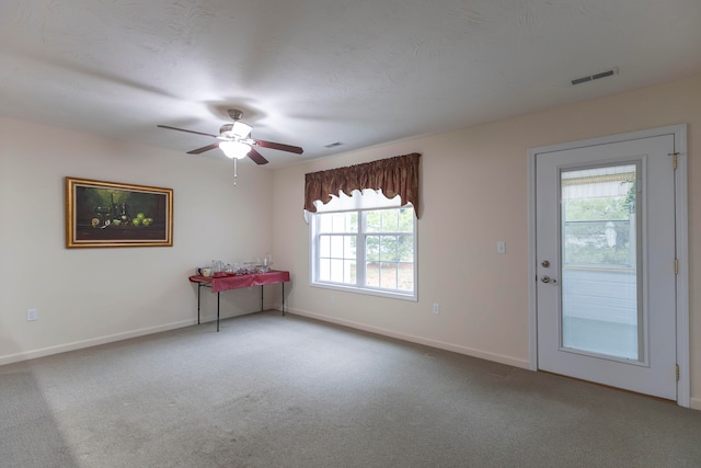 unfurnished room featuring carpet, plenty of natural light, and ceiling fan