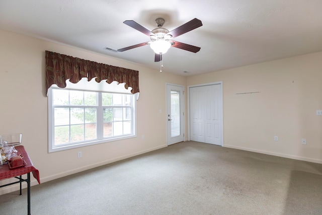 carpeted empty room featuring ceiling fan