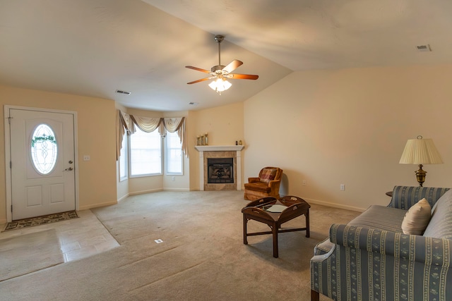 living room with a tile fireplace, lofted ceiling, ceiling fan, and a healthy amount of sunlight