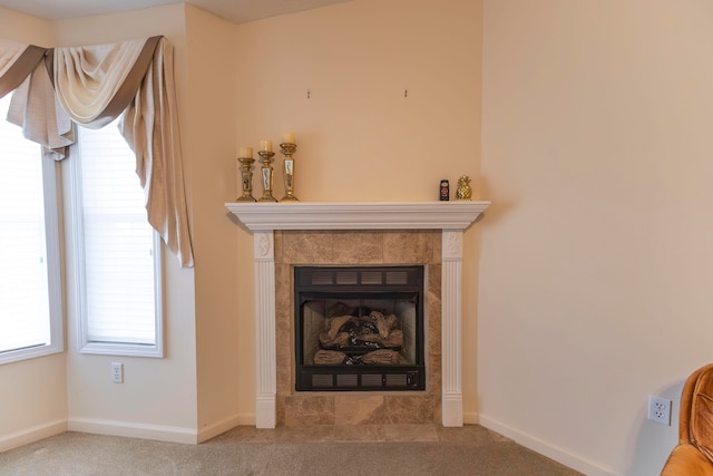 details with a tile fireplace and carpet floors