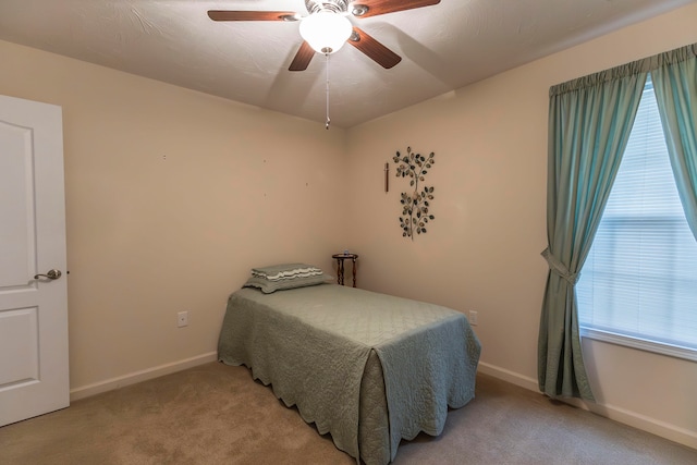 bedroom with ceiling fan and light carpet