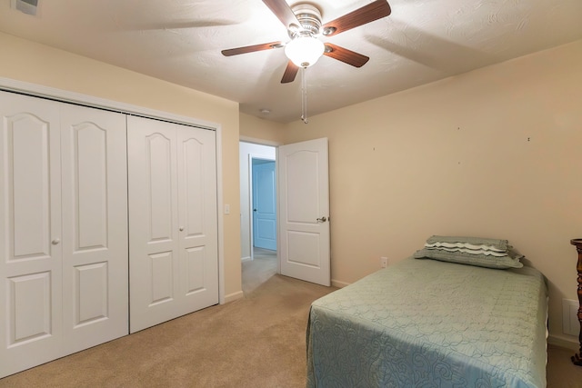 carpeted bedroom featuring a closet and ceiling fan