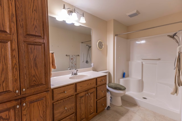 bathroom featuring a shower, vanity, and toilet