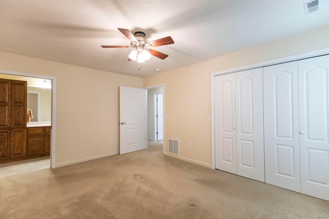 unfurnished bedroom with connected bathroom, light carpet, a closet, and ceiling fan