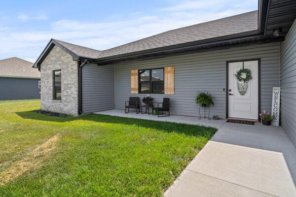 doorway to property with a lawn