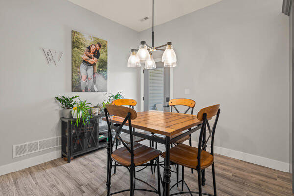 dining space with a notable chandelier and hardwood / wood-style flooring