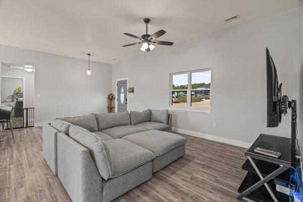 living room with hardwood / wood-style floors and ceiling fan