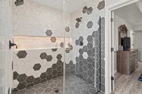 bathroom featuring hardwood / wood-style floors and tiled shower